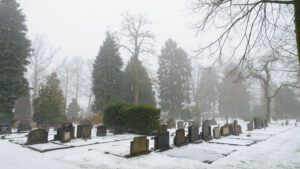 Grafstenen op de besneeuwde graafplaats van Brummen