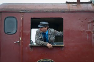 De machinist op een oude diesel trein tijdens het stoomtreinenfestival