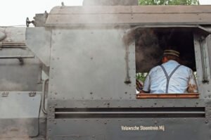 De achterkant van een machinist op een trein tijdens het stoomtreinenfestival