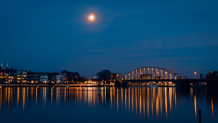 De brug van Deventer in de schemering met maan.