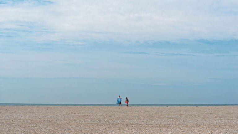 Eenzame strandgangers op het strand van de Maasvlakte