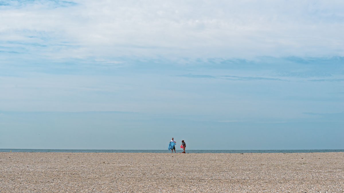 Eenzame strandgangers op het strand van de Maasvlakte